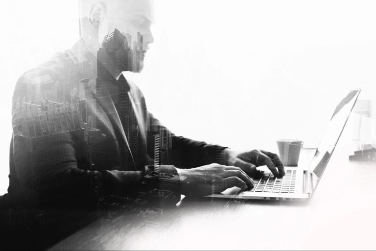 Professional accountant working on a laptop with cityscape overlay for Harlan Willow Accounting Group.
